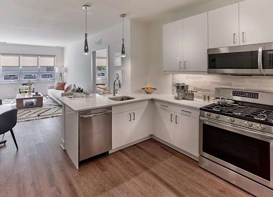 A modern kitchen with stainless steel appliances and white cabinets.