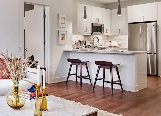 A kitchen with a white counter top and a stainless steel refrigerator.