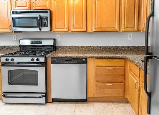 A kitchen with a stove, oven, microwave, and refrigerator.