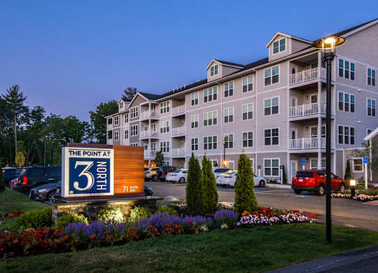 The Point at North apartments are lit up at dusk.