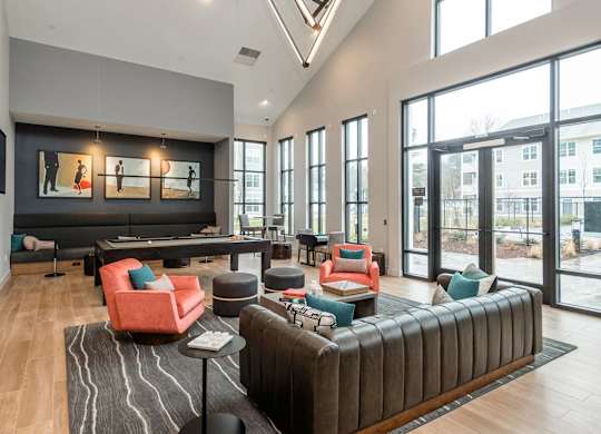A spacious living room with a large sectional sofa and a long table with chairs.