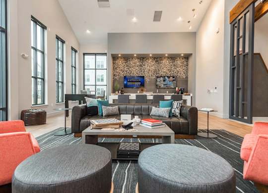 A modern living room with a grey sofa, a coffee table, and a TV mounted on the wall.