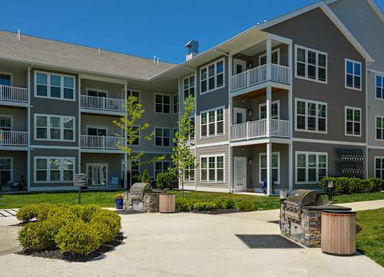 Apartment complex with a large courtyard and a tree in the middle.