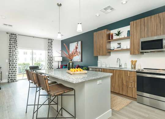 A kitchen with a large island and chairs.