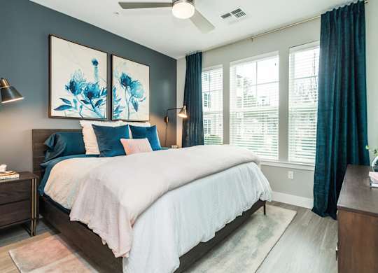 A bedroom with a large bed and a ceiling fan.