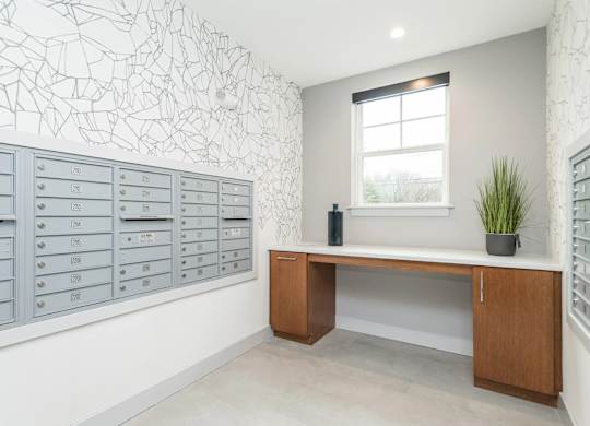 A room with a desk, drawers, and a window.