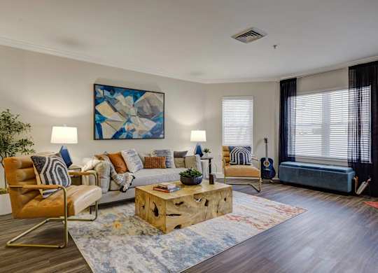 A living room with a wooden floor and a large painting on the wall.