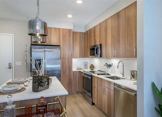A modern kitchen with wooden cabinets and stainless steel appliances.