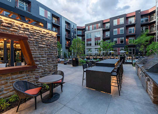 A patio with a table and chairs is surrounded by buildings.