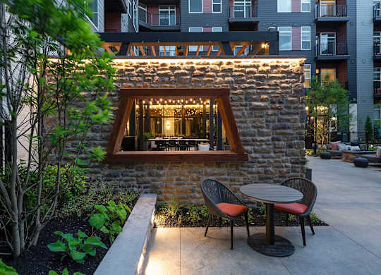 A small stone building with a window and lights on it.