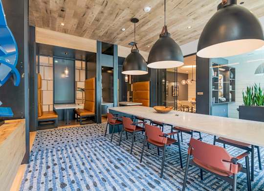 A modern dining area with a long table and chairs.