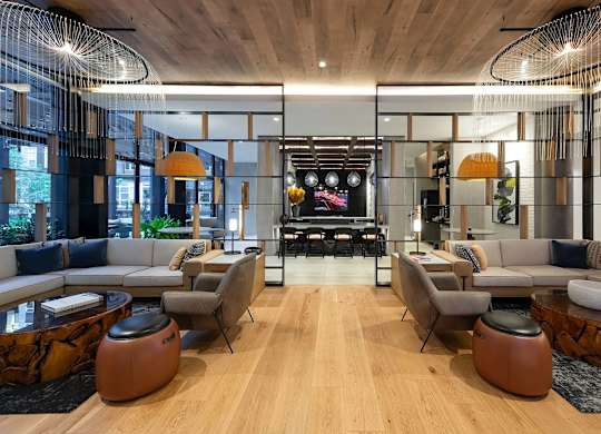 A modern living room with a wooden floor and a large TV in the background.