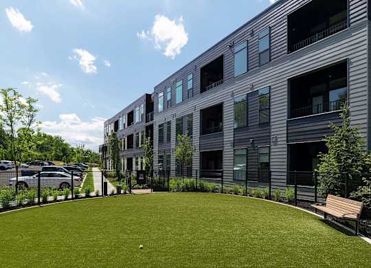 A modern building with a grassy area in front.