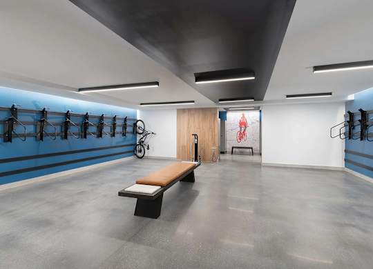 A gym with a bench, a bicycle, and racks of equipment.