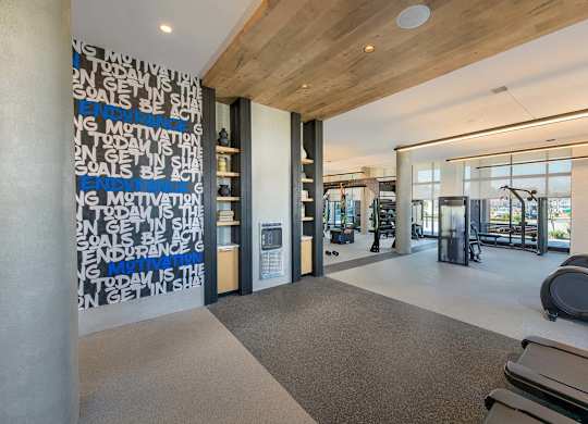 A gym with a motivational wall and exercise equipment.
