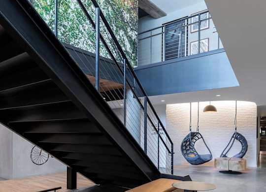 A modern staircase with a glass railing and wooden steps.