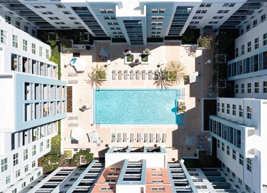 A swimming pool is surrounded by buildings.