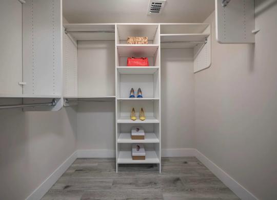 A white shoe rack with various shoes on it.