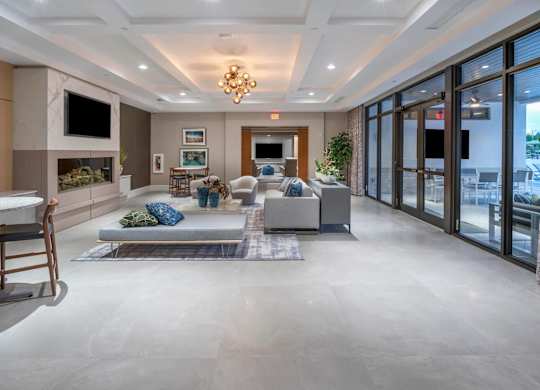 A spacious living room with a grey sofa and a chandelier.
