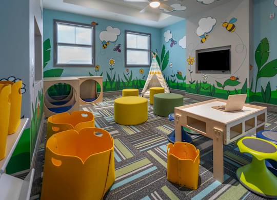 A child's playroom with a wooden table and yellow chairs.
