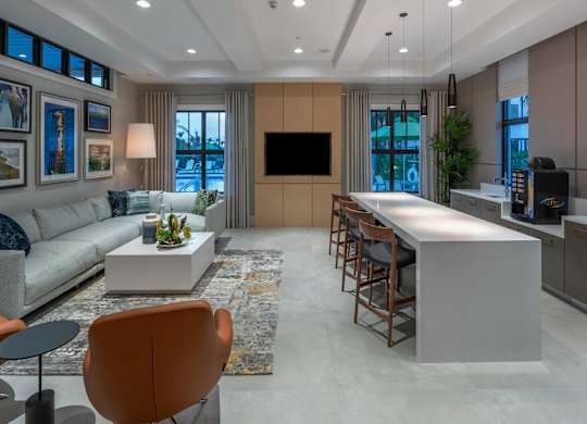 A modern living room with a grey sofa, a white coffee table, and a large flat screen TV.