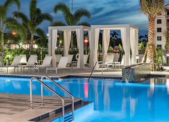 A pool with a staircase and a white canopy.