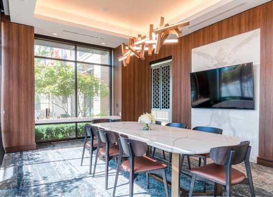 A dining room with a large table and chairs.
