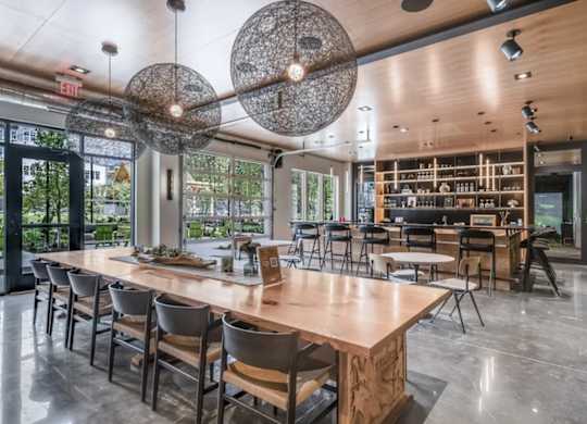A modern dining room with a long wooden table and chairs.