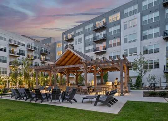 A modern apartment complex with a communal outdoor seating area.