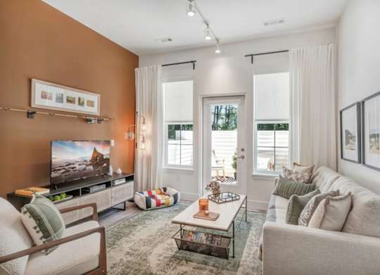 A living room with a television, couch, and coffee table.