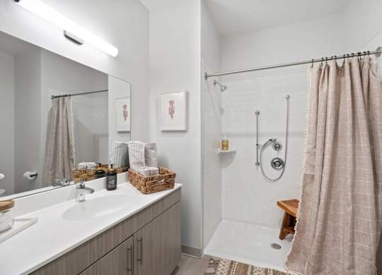 A bathroom with a white sink, a white tub, and a brown shower curtain.