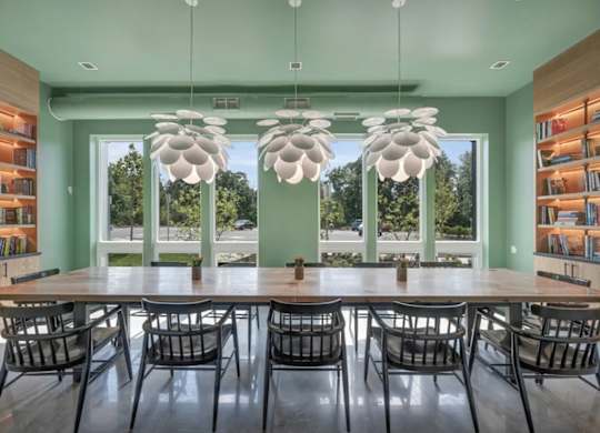 A dining room with a long table and chairs.