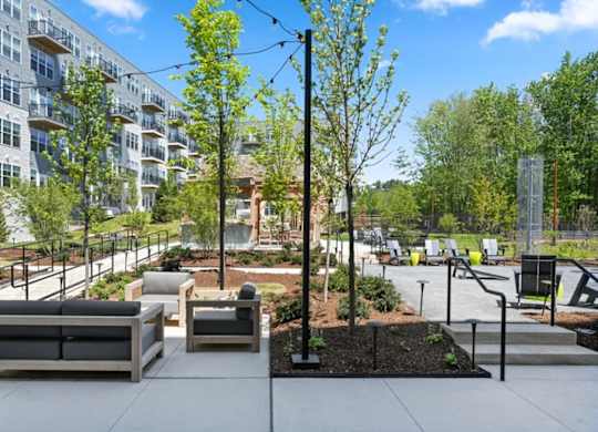 A modern outdoor seating area with benches and trees.