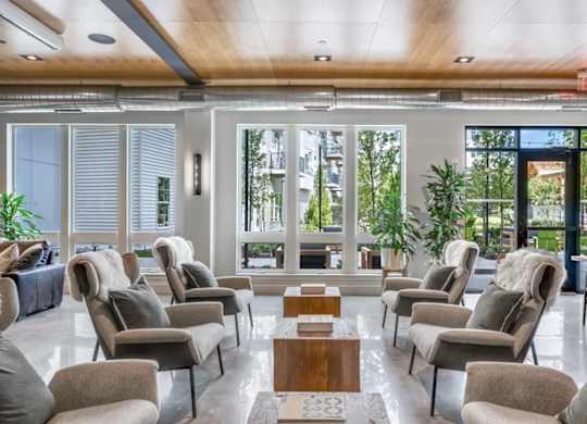 A room with grey chairs and a wooden table.