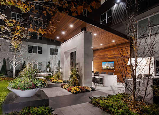 A modern house with a wooden exterior and a garden in front.