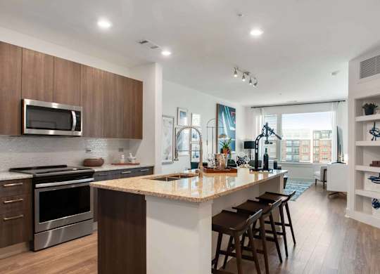 A modern kitchen with a large island and wooden cabinets.