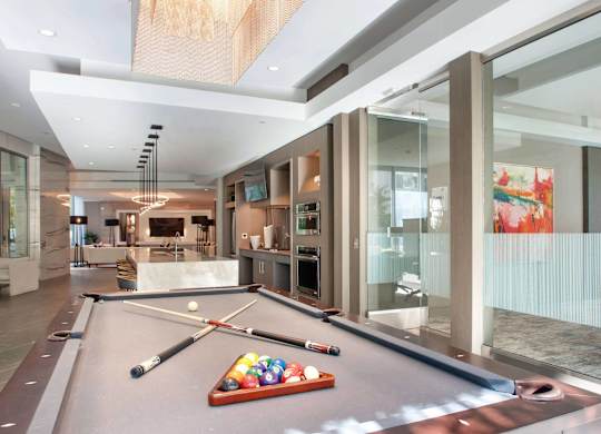 A pool table in a room with a glass wall.