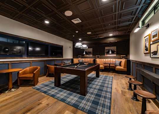 A room with a wooden floor and a blue plaid rug.