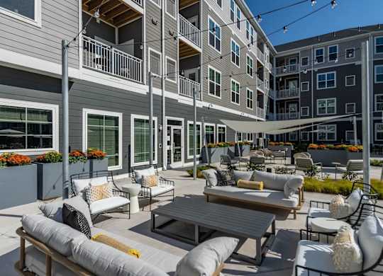 A patio with a table and chairs is surrounded by buildings.
