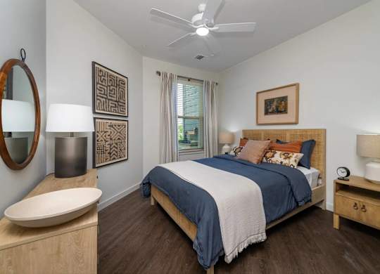 A bedroom with a bed, nightstand, and a mirror.