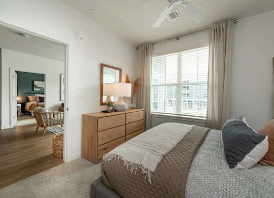 A bedroom with a bed, dresser, and mirror.
