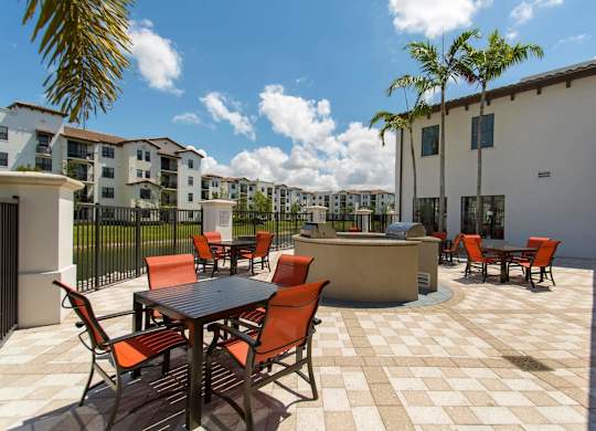 A patio with a table and chairs is surrounded by buildings.