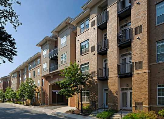 A row of apartment buildings with balconies and doors.