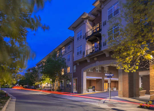 A street view of a residential area with apartment buildings and a street sign.