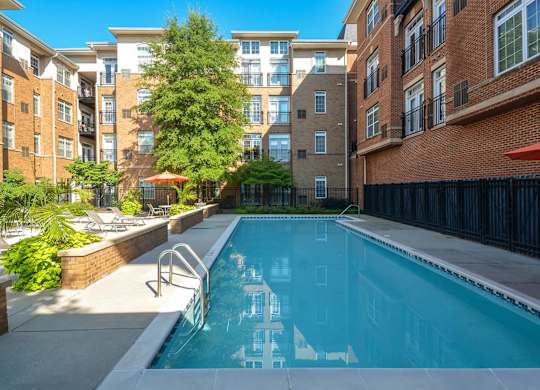 A swimming pool in a courtyard surrounded by buildings.