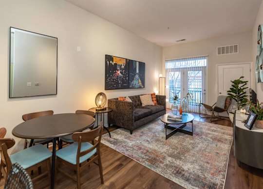 A living room with a couch, a table, and a painting on the wall.