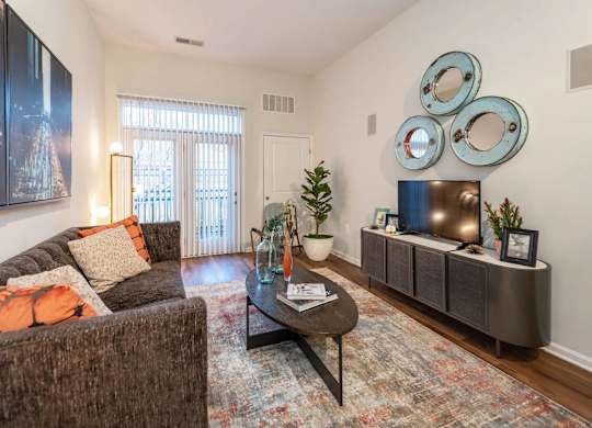 A living room with a brown couch, a coffee table, and a large painting on the wall.