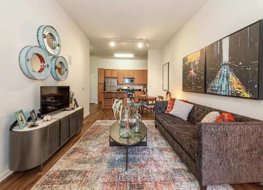 A living room with a brown couch and a large painting on the wall.