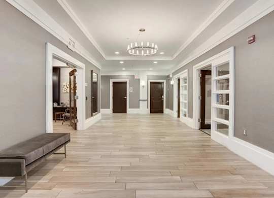 A long hallway with a bench and doors on both sides.