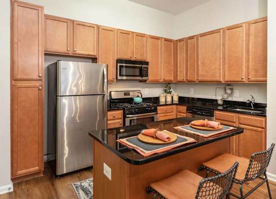 A kitchen with wooden cabinets and a black countertop.